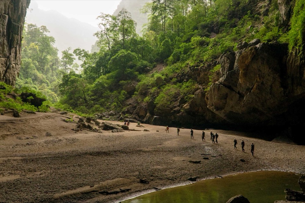 A caving party crossing a cave mouth, Vietnam